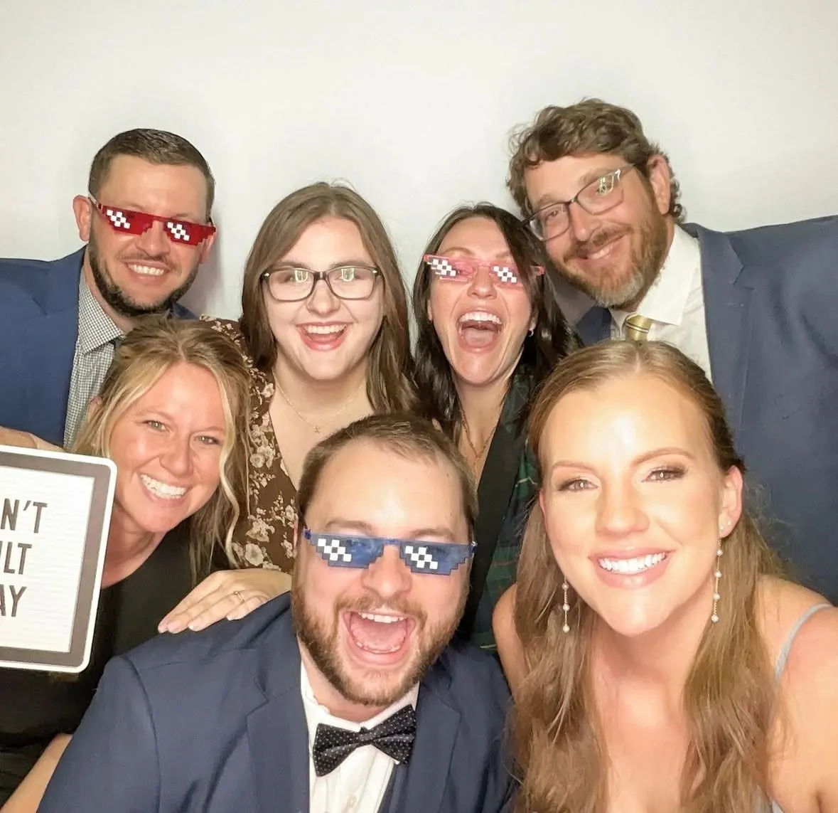 Friends laughing together in the photo booth at a wedding reception